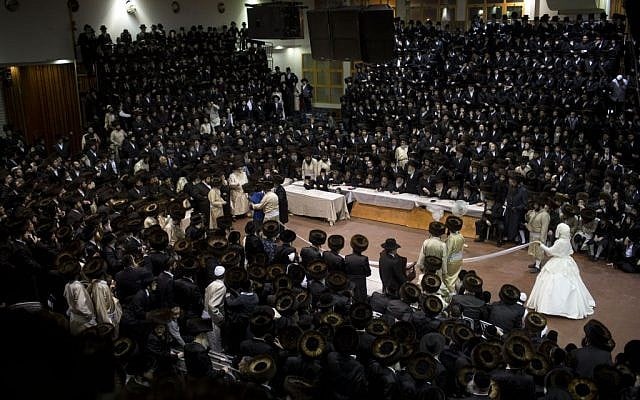 An ultra-Orthodox Jewish bride enters to the men's section of the wedding, to fulfill the Mitzvah tantz, in which family members and honored rabbis are invited to dance in front of the bride, often holding a gartel, and then dancing with the groom, during her wedding to the grandson of the Rabbi of the Tzanz Hasidic dynasty community, in Netanya, Israel, Wednesday, March 16, 2016. (AP Photo/Oded Balilty)