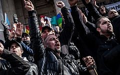 Far-right demonstrators protest at a memorial site at the Place de la Bourse in Brussels, Sunday, March 27, 2016. (AP Photo/Valentin Bianchi)