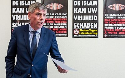 Far right Flemish Interest leader Filip Dewinter addresses the media on his party's proposals to fight terrorism, at the Belgian federal parliament in Brussels, Tuesday, March 29, 2016. The posters on the back read in Dutch: "Islam can harm your freedom". (AP Photo/Geert Vanden Wijngaert)