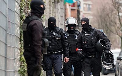 Police officers stand guard during a raid in the Molenbeek neighborhood of Brussels, Belgium, on March 18, 2016. (AP/Geert Vanden Wijngaert)