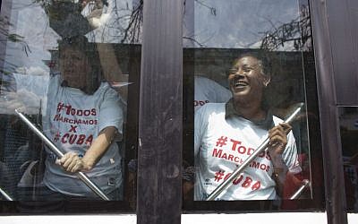 Government supporters wearing shirts that read in Spanish: "We all march for Cuba" leave in a bus after staging a counter-protest to the weekly march by Ladies in White, a dissident women's group that calls for the release of political prisoners, in Havana, Cuba, Sunday, March 20, 2016. (AP Photo/Rebecca Blackwell) Government supporters wearing shirts that read in Spanish: "We all march for Cuba" leave in a bus after staging a counter-protest to the weekly march by Ladies in White, a dissident women's group that calls for the release of political prisoners, in Havana, Cuba, Sunday, March 20, 2016. (AP Photo/Rebecca Blackwell)