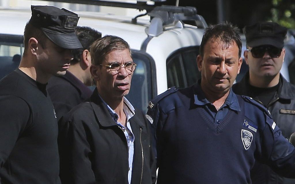 EgyptAir plane hijacking suspect Seif Eddin Mustafa, second left, is escorted by Cyprus police officers as he leaves a court after a remand hearing as authorities investigate him on charges including hijacking, illegal possession of explosives and abduction in the Cypriot coastal town of Larnaca Wednesday, March 30, 2016 (AP Photo/Petros Karadjias)