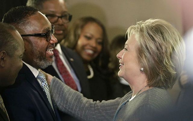 Democratic presidential candidate Hillary Clinton meets with the Rev. Kenneth J. Flowers of the Greater New Mt. Moriah Missionary Baptist Church before meeting with African American ministers, Saturday, March 5, 2016, in Detroit, Michigan. (AP Photo/Carlos Osorio)