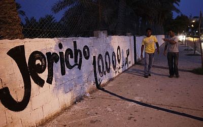 Palestinians walk by a wall painted in honor of festivities marking 10,000 years of the West Bank city of Jericho. Jericho is believed to be one of the oldest continuously inhabited cities of the world. October 10, 2010. (Miriam Alster/Flash90)