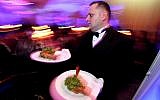 Illustrative image of a waiter bringing out food at a restaurant on December 5, 2010. (Moshe Shai/FLASH90)