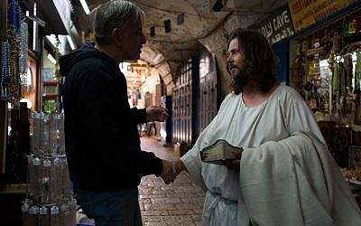 A man dressed as Jesus Christ greets a storeowner in the Old City of Jerusalem on May 13 2013. (Sarah Schuman/ Flash90)