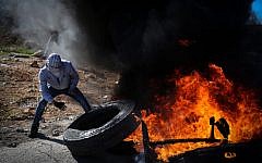 Palestinian protesters burn tires and hurl stones towards Israeli troops during clashes in Aboud village, near the West Bank city of Ramallah on December 5, 2015. (FLASH90)