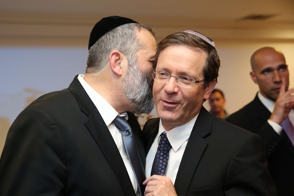 Aryeh Deri, left, whispering to Isaac Herzog at a party in Jerusalem on December 23, 2015. (Yaacov Cohen/FLASH90) Aryeh Deri, left, whispering to Isaac Herzog at a party in Jerusalem on December 23, 2015. (Yaacov Cohen/FLASH90)