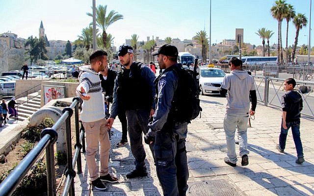 Illustrative: Israeli police officers search a Palestinian man at Damascus Gate in Jerusalem on February 26, 2016. (Haytham Shtayeh/Flash90)