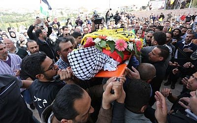 Palestinian mourners chant slogans while carrying the body of Mahmoud Shalan, 17, during his funeral in the West Bank village of Deir Debwan, near Ramallah, March 2, 2016. (Photo by Flash90)