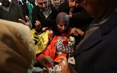 Palestinian mourners chant slogans while carrying the body of Mahmoud Shalan, 17, during his funeral in the West Bank village of Deir Debwan, near Ramallah, March 2, 2016. (Photo by Flash90)