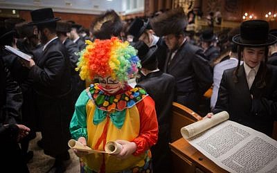 Ultra-Orthodox Jewish men and children read the Scroll of Esther, which tells the story of the Jewish festival of Purim, at a Jerusalem yeshiva on March 24, 2016. (Yonatan Sindel/Flash90)