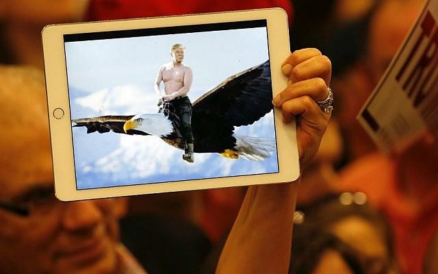 A supporter of Republican presidential candidate Donald Trump holds up an illustration of him riding shirtless on the back of a Bald Eagle, as he greets the crowd after speaking at a campaign rally in New Orleans, Louisiana, Friday, March 4, 2016. (AP Photo/Gerald Herbert)