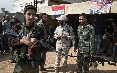In this photo taken on Wednesday, March 2, 2016, Syrian solders guard near a tent where local leaders and elders signed a declaration pledging to abide by a truce Maarzaf, about 15 kilometers west of Hama, Syria. Associated Press spent five days traveling through the port of Latakia and the surrounding areas in Syria during the cease-fire. (AP Photo/Pavel Golovkin)