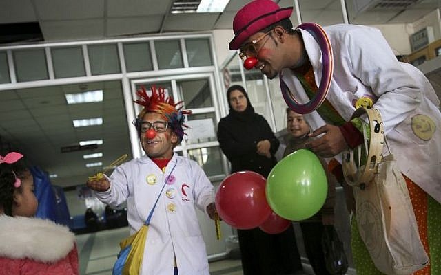 Palestinian medical clowns, 24-year-old Majed Kaloub, right, and 33-year-old Alaa Miqdad, center, entertain children at Al-Rantisi children’s hospital in Gaza City, March 17, 2016. (AP/Adel Hana) 