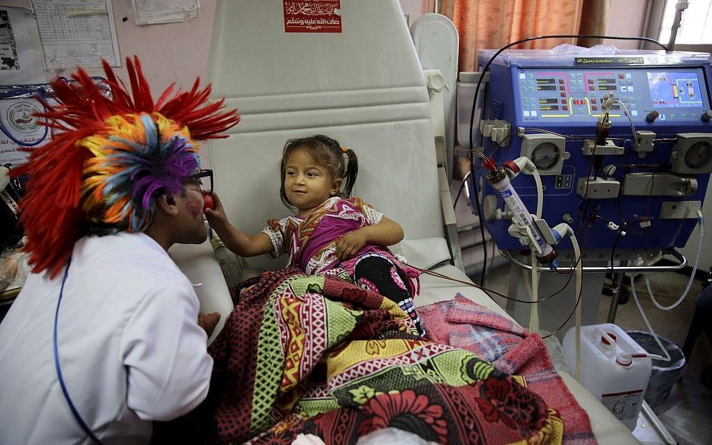 33-year-old Palestinian clown doctor Alaa Miqdad, left, entertains 3-year-old patient Yaqin Shawaf, who suffers from dialysis, in the department of kidney diseases at Al-Rantisi children’s hospital in Gaza City, March 17, 2016. (AP/Adel Hana) 33-year-old Palestinian clown doctor Alaa Miqdad, left, entertains 3-year-old patient Yaqin Shawaf, who suffers from dialysis, in the department of kidney diseases at Al-Rantisi children’s hospital in Gaza City, March 17, 2016. (AP/Adel Hana)
