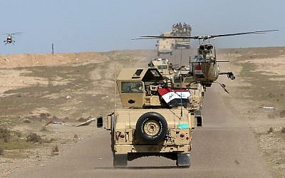In this Wednesday, March 9, 2016 photo, Iraqi Defense Minister Khaled al-Obeidi's convoy tours the front line in Anbar, Iraq. (AP Photo/Hadi Mizban)