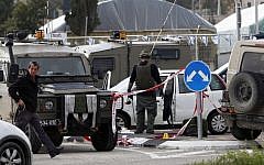 Israeli soldiers and police officers at the scene of an attack at the Gush Etzion junction in the West Bank Friday, March 18, 2016. (AP Photo/Mahmoud Illean)