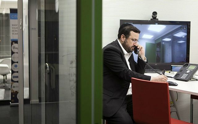 In this photo taken Tuesday, March 15, 2016, Moshe Friedman, a co-founder of KamaTech, speaks on the phone in a high tech start-up office in Tel Aviv. (AP Photo/Dan Balilty)