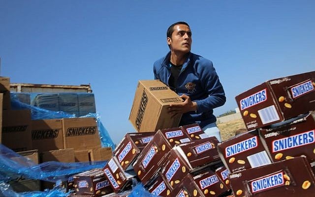 A Palestinian worker throws a box of Snickers chocolate in a hole to be burned, on the outskirts of Gaza City, Thursday, March 10, 2016. (AP Photo/Adel Hana) A Palestinian worker throws a box of Snickers chocolate in a hole to be burned, on the outskirts of Gaza City, Thursday, March 10, 2016. (AP Photo/Adel Hana)