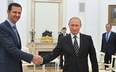 Russian President Vladimir Putin, center, shakes hand with Syrian President Bashar Assad as Russian Foreign Minister Sergey Lavrov, right, looks on in the Kremlin in Moscow, Russia, Tuesday, October 20, 2015. (Alexei Druzhinin, Sputnik, Kremlin Pool Photo via AP, File)