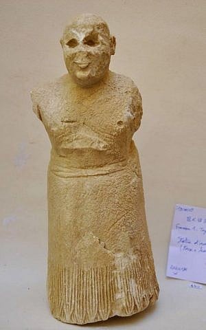 A clay statue of a smiling worshiper dating from nearly 5,000 years ago, discovered in 2009 among a cache of statues buried under a stair in an early 3rd millennium BCE temple in the ancient city of Mari, Syria. (DGAM via AP)