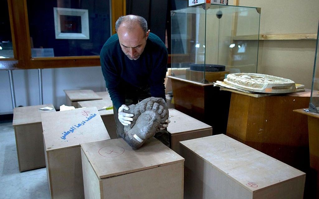 Jihad Abu Kahrlah, an archaeologist at the National Museum in Damascus, Syria, works on preserving artifacts rescued from the Daraa Museum in southern Syria, February 23, 2016. (AP Photo/Hassan Ammar)