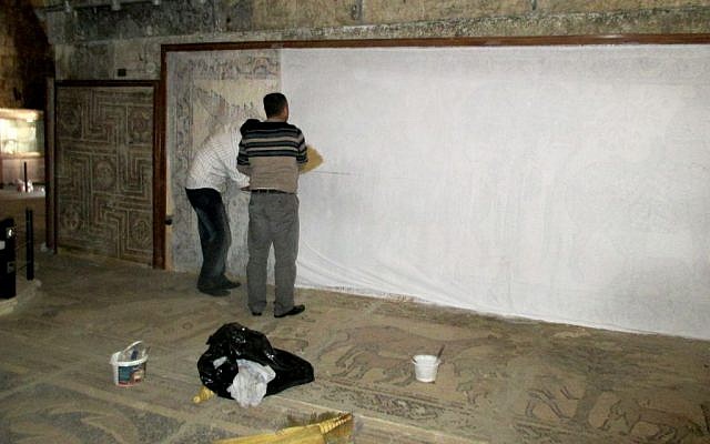 Archaeologists using water based glue to paste sheets on mosaics for protection from mortar shells or bombings in the Maarat al-Numan Mosaics Museum in Idlib province, Syria. (The Day After Heritage Initiative via AP)