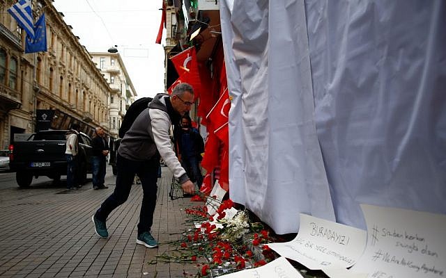 A man leaves carnations at the site of a suicide bombing in Istanbul on Sunday, March 20, 2016, a day after the attack, which killed four, including three Israeli tourists (AP Photo/Emrah Gurel)