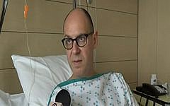 Walter Benjamin speaking to Israel’s Channel 2 News from his hospital bed in Brussels, March 28, 2016. (Screenshot from Channel 2)