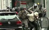 Belgian police arrest a suspect believed to be Paris terror suspect Salah Abdeslam during a raid in the Brussels neighborhood of Molenbeek on March 18, 2016 (screen capture: YouTube)