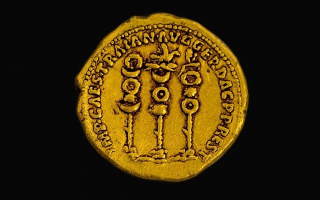 Symbols of the Roman legions next to the name of the ruler Trajan on a 2,000 year old gold coin found in northern Israel. (Samuel Magal, courtesy of the Israel Antiquities Authority)