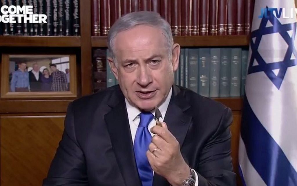 Prime Minister Benjamin Netanyahu holds up a replica Roman arrow while speaking to the AIPAC conference on March 22, 2016. (screen capture: JLTV/YouTube)