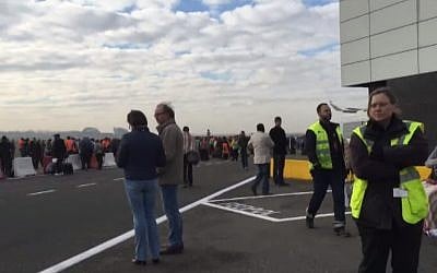 Passengers stand on the tarmac after they were evacuated from Brussels following twin blasts on March 22, 2016 (screen capture: YouTube)