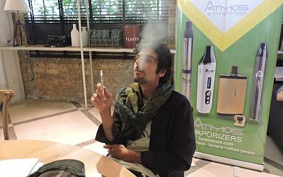Arnon Tamir, CEO of Teva Nature, smoking a cannabis extract through an electronic cigarette at the CannaTech conference in Tel Aviv, March 7, 2016. (Ben Sales/JTA)