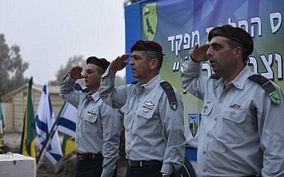 Brig.-Gen. Ofek Buchris, right, salutes during a ceremony to mark his exit as commander of the Bashan Division, along with head of the Northern Command Maj.-Gen. Aviv Kochavi, center, and Brig.-Gen. Yaniv Asur, in September 2015. (IDF Spokesperson's Unit)
