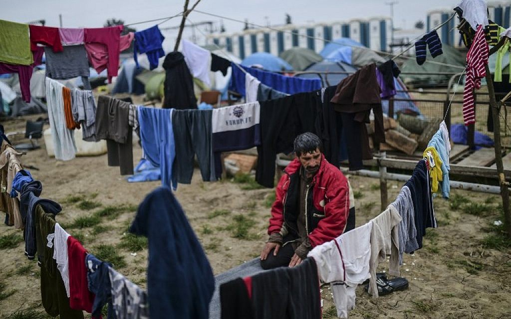 A man prays at a makeshift camp set by refugees and migrants stranded by the Balkan border blockade, on April 3, 2016 near the village of Idomeni at the Greek Macedonian border (AFP/BULENT KILIC)