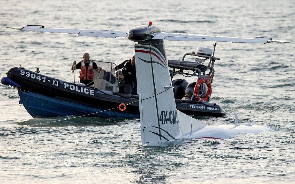 A rescue boat works to secure a cable around the tail of a light aircraft after it made an emergency landing in the Mediterranean Sea off the shore of Tel Aviv, on April 3, 2016.  (AFP/JACK GUEZ)
