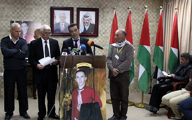 Palestinian doctor, Rayan al-Ali, who carried out the autopsy on 21-year-old Palestinian Abdul Fatah al-Sharif, pictured on poster, speaks during a press conference in the West Bank town of Hebron on April 4, 2016. (AFP / HAZEM BADER)