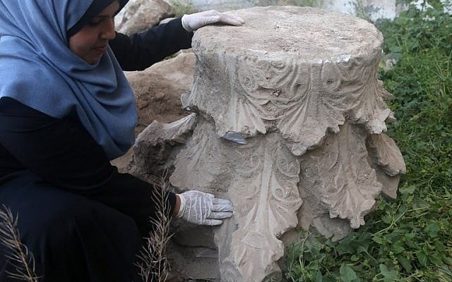 A Palestinian archaeologist looks at artifacts excavated during the construction of a commercial building in Gaza City, on April 4, 2016. (AFP/MOHAMMED ABED)