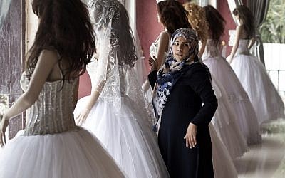 A Palestinian girl looks at wedding dresses at a shop in Gaza City on April 5, 2016. (AFP PHOTO / MAHMUD HAMS)