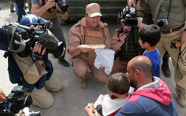 A picture taken during a press tour organized by the Russian Army shows Russian journalists working next to a Russian soldier talking with Syrians on April 8, 2016 in al-Qaryatain. (AFP PHOTO / Max DELANY) A picture taken during a press tour organized by the Russian Army shows Russian journalists working next to a Russian soldier talking with Syrians on April 8, 2016 in al-Qaryatain. (AFP PHOTO / Max DELANY)