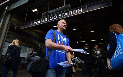 A campaigner with Britain Stronger in Europe, the official Remain campaign in June's EU referendum, hands out leaflets to commuters outside Waterloo Station in London on April 14, 2016. (AFP PHOTO/BEN STANSALL)