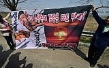 South Korean conservative activists display a banner showing a caricature of North Korean leader Kim Jong-Un as police block the activists attempting to launch anti-North Korea balloons in the border city of Paju on April 15, 2016.  (Jung Yeon-Je/AFP)