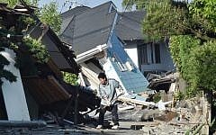 A man clears away debris of a broken wall in Mashiki, Kumamoto prefecture on April 16, 2016, after a powerful earthquake hit southern Japan, the second in two days. (AFP PHOTO/KAZUHIRO NOGI)