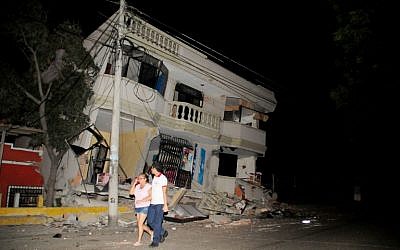 Residents walk on a street amid destroyed buildings following an earthquake, April 16, 2016 in Guayaquil, Ecuador. (AFP PHOTO / ARIEL OCHOA)