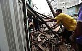 People help to clean the rubble after a 7.8-magnitude quake in Portoviejo, Ecuador, on April 17, 2016. (AFP/Juan Cevallos)