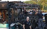 Israeli police check a burned-out bus that was blown up in a terror attack in Jerusalem on April 18, 2016. (AFP/Ahmad Gharabli)