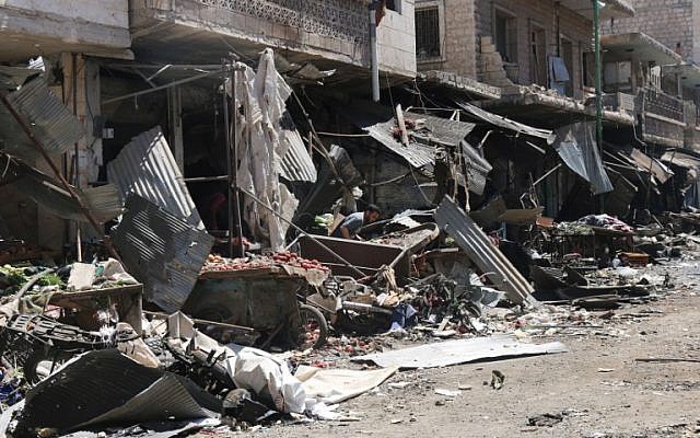 A Syrian man stands amid debris following an air strike on a vegetable market in Maaret al-Numan, in Syria's northern province of Idlib, April 19, 2016. (AFP Photo/Mohamed al-Bakour)
