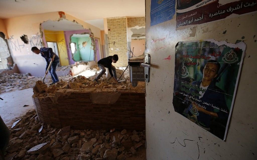 Palestinians inspect the damage at the apartment of Hussein Abu Ghosh, a Palestinian assailant who stabbed a woman to death in January, after it was partially destroyed by Israeli forces on April 20, 2016, at the Qalandia refugee camp in the West Bank. (AFP/ ABBAS MOMANI)